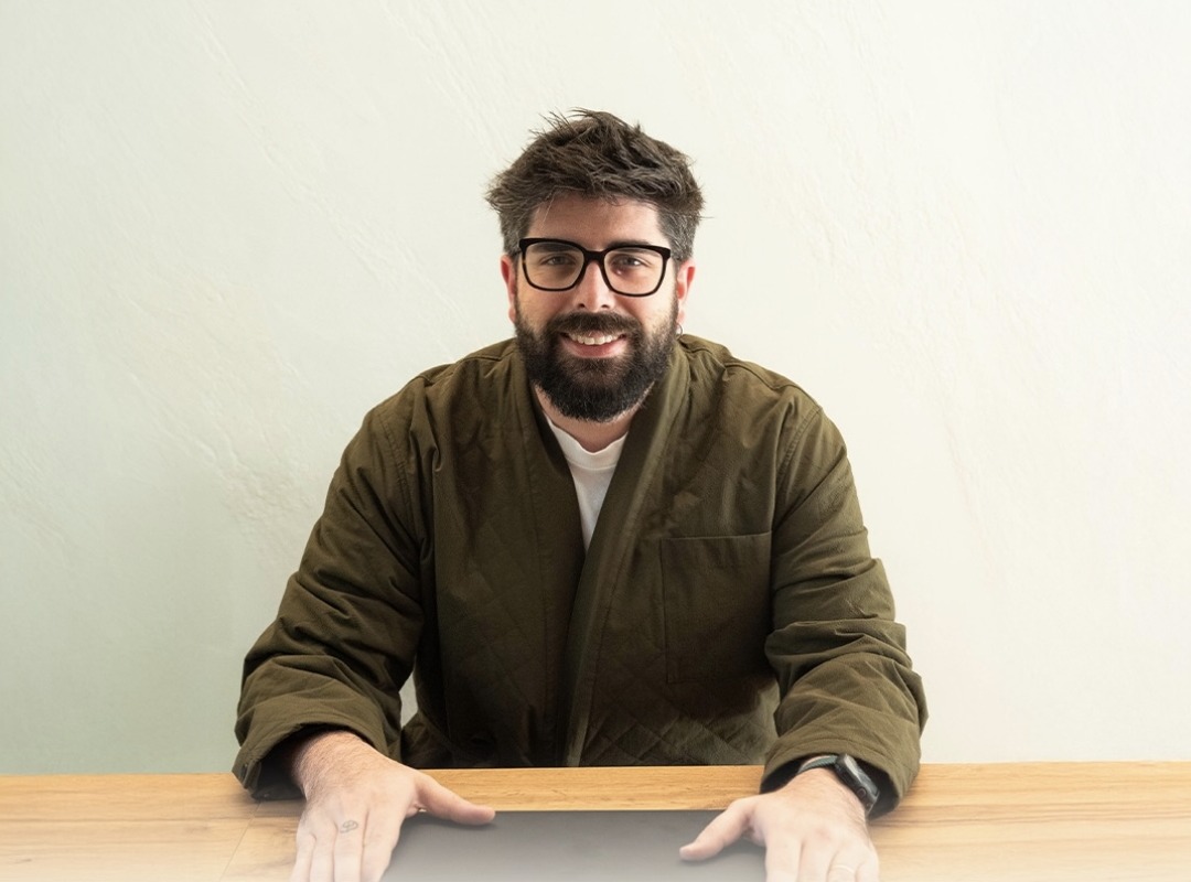 Mattia Pasqualini, pedagogista, seduto alla scrivania